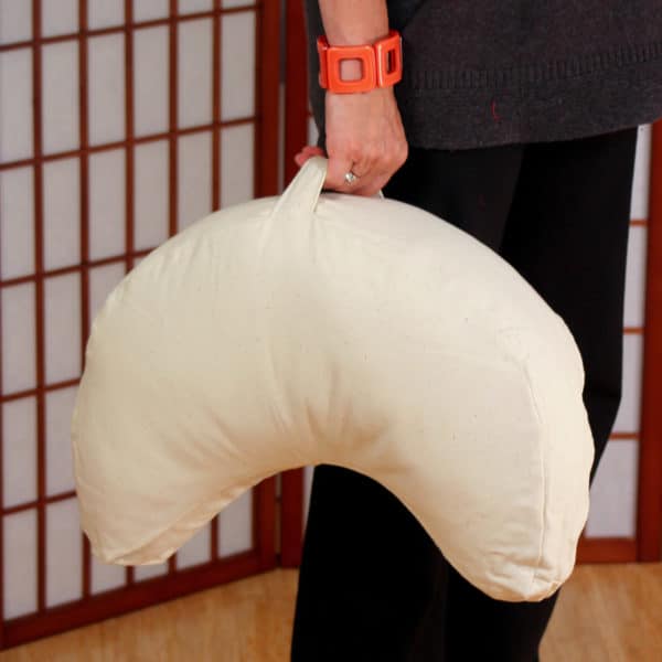 Crescent Zafu meditation cushion being held by handlenatural