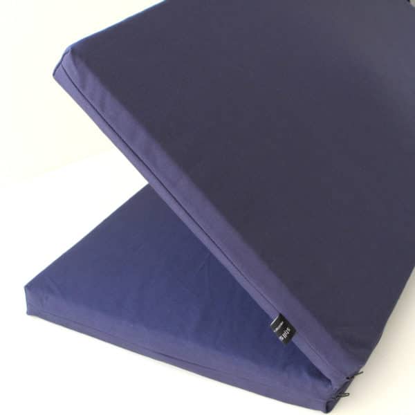 Blue folding zabuton meditation cushion in process of folding
