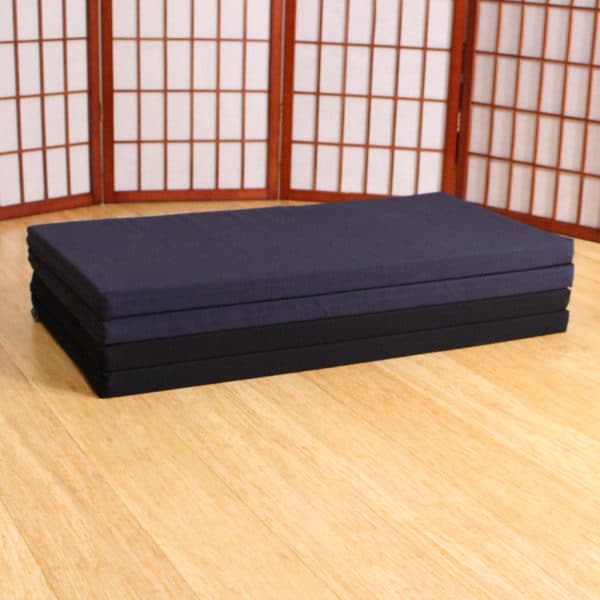 Black and blue stacked folding zabuton meditation cushions on floor