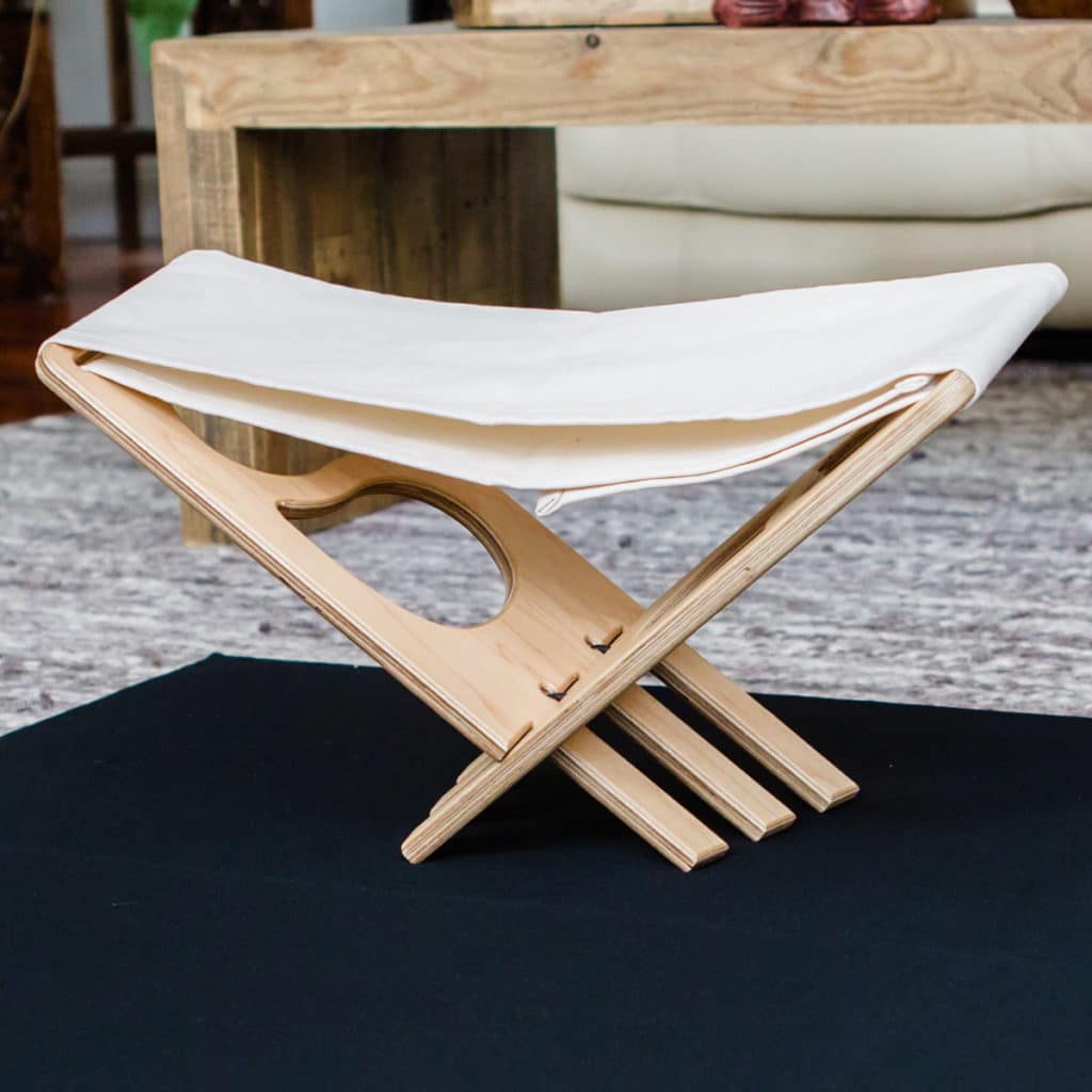 Nomad folding meditation bench on black zabuton in living room