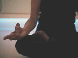 A person sitting in meditation with a mudra